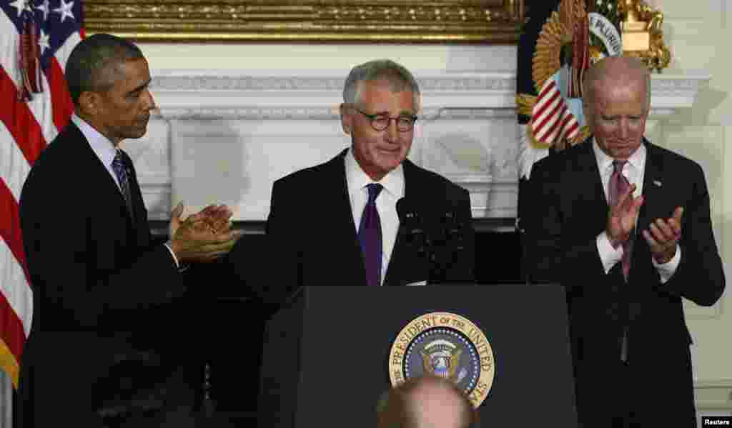 U.S. President Barack Obama and Vice President Joe Biden (R) applaud Defense Secretary Chuck Hagel after the president announced Hagel's resignaton at the White House in Washington, Nov. 24, 2014.