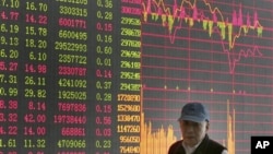 投资者走过上海证券公司的股市行情屏幕