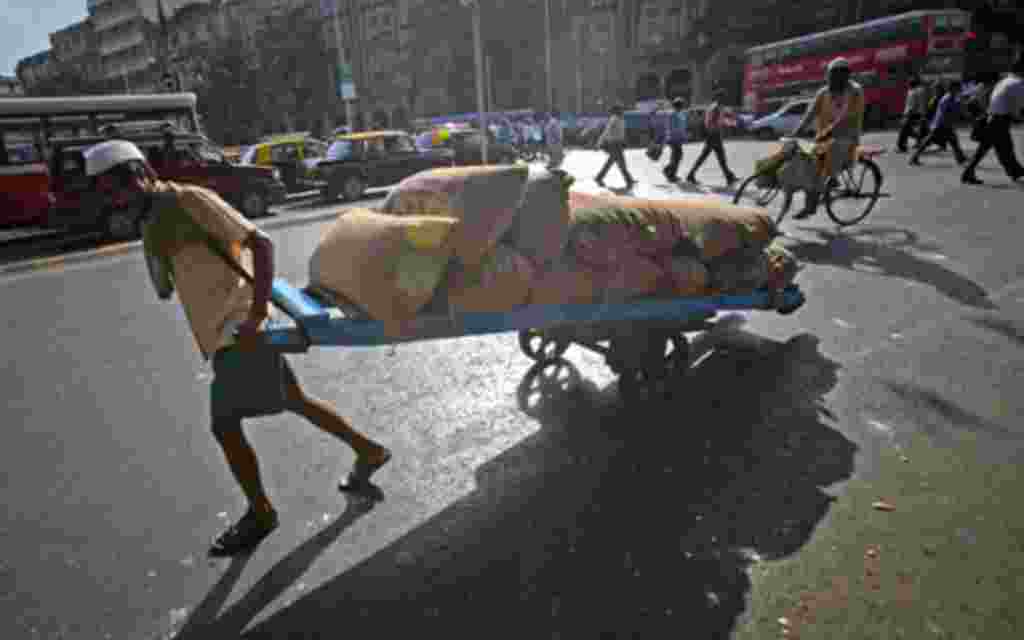 A man pulls a hand-drawn cart loaded with sacks of chickpeas on a main road in Mumbai. Annual food inflation snapped a three-week easing trend on April 9, while fuel inflation also quickened, raising the odds for an aggressive rate hike by the central ban