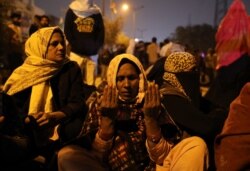 Seorang perempuan berdoa ketika orang lain berdemonstrasi setelah orang tak dikenal melepaskan tembakan ke lokasi di mana orang-orang memprotes Undang-undang kewarganegaraan baru di daerah Shaheen Bagh di New Delhi, India, 1 Februari 2020. (Foto: REUTERS)