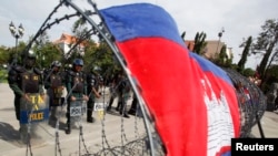 Police officers stand guard at Freedom Park during a protest in central Phnom Penh July 15, 2014. 