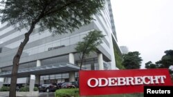 FILE - Federal police cars are parked in front of the headquarters of Odebrecht, a large private Brazilian construction firm, in Sao Paulo, Brazil, June 19, 2015. 