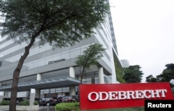 FILE - Federal police cars are parked in front of the headquarters of Odebrecht, a large private Brazilian construction firm, in Sao Paulo, Brazil, June 19, 2015.