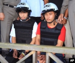 Workers from Myanmar accused of murdering two UK tourists, Saw, left, and Win, sit together during a press conference in Koh Tao island, Surat Thani province, Thailand, Friday, Oct. 3, 2014.