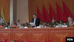FILE - Union Minister U Thein Swe reads a statement from ASSK, standing next to UWSA chief Bao Youxiang, second right, and China Special Envoy for Asian Affairs, Sun Guoxiang, far right, during the 30-year anniversary in Panghsang, Special Region 2, April 17, 2019. (Am Sandford/AsiaReports)