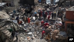 Civil protection rescue team work on the debris of a destroyed house to recover the bodies of people killed on the western side of Mosul, Iraq, March 24, 2017.