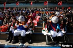 FILE - Mascots and attendants from the Hong Kong Jockey Club sit on the spectators' stand at Shatin race track in Hong Kong, Dec. 11, 2011. A large share of losing bets contributes directly to the welfare of Hong Kong's society through charitable contributions by the club.