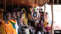 Refugees take shelter from the scorching sun as they wait to register at Yida refugee camp in South Sudan's Upper Nile, August 2012. (VOA - H. McNeish)