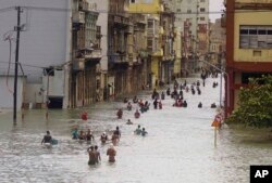 People move through flooded streets in Havana after the passage of Hurricane Irma, in Cuba, Sept. 10, 2017.