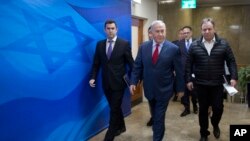 FILE - Israeli Prime Minister Benjamin Netanyahu, escorted by his spokesman David Keyes, left, arrives for the weekly cabinet meeting at his office in Jerusalem, March 11, 2018.