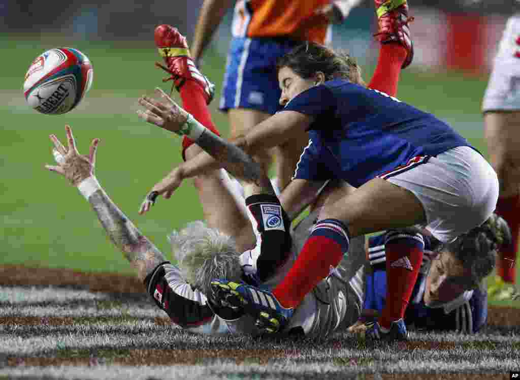 Canada&#39;s Jennifer Kish, left on the ground, is tackled by France&#39;s Jade Le Pesq, right, during the final match of Women&#39;s Invitational Cup at the Hong Kong Sevens rugby tournament.