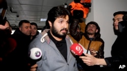 FILE - Turkish-Iranian businessman Reza Zarrab, charged in the U.S. with allegedly evading sanctions on Iran, is surrounded by reporters as he arrives at a courthouse in Istanbul, in a separate case against him, Dec. 17, 2013.