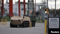 FILE - A pair of armored personnel carriers are parked on the grounds of the General Dynamics Land Systems - Canada factory in London, Ontario, Canada Oct. 23, 2018.