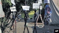 Hanging ropes with names in Arabic for officials from the ousted regime - "Zusan, Jamal Mubarak, Ahmed Ezz, Habib al-Adly and Hosni Mubarak" - are seen at the protest camp in Tahrir square, Cairo, Egypt, July 26, 2011