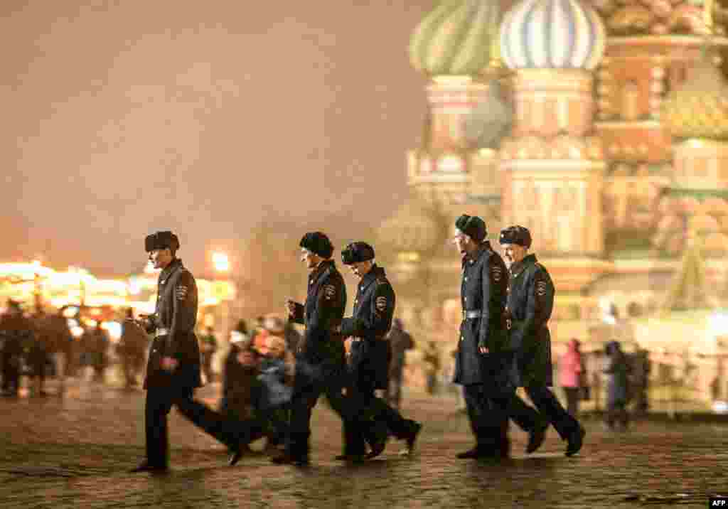 Military cadets walk under the snow in front of St Basil Cathedral on Red Square in Moscow.