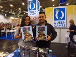 Kwanchai Moriya (right), a Thai-Japanese boardgame illustrator, shows a board game he illustrated.