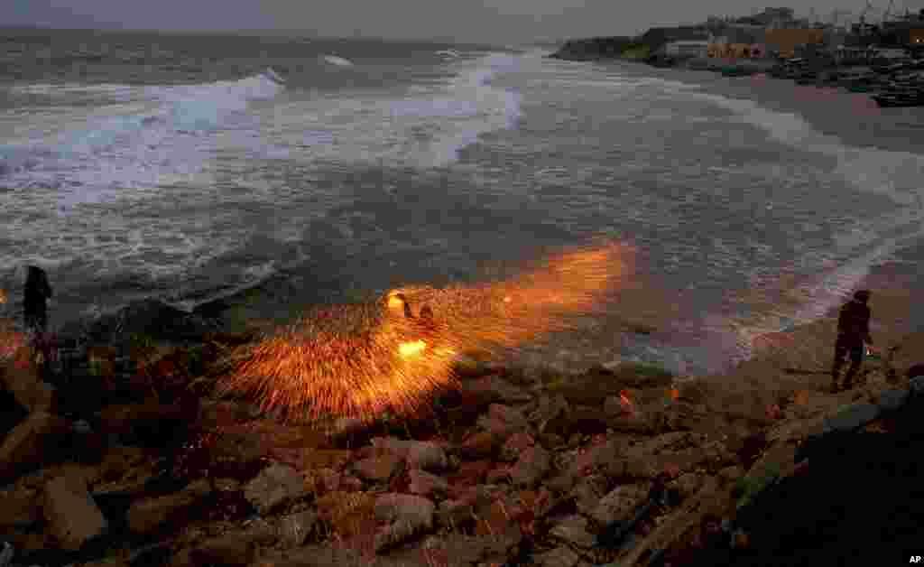 A man swings fireworks during the Muslim holy fasting month of Ramadan, on the beach of Gaza City, April 26, 2021.