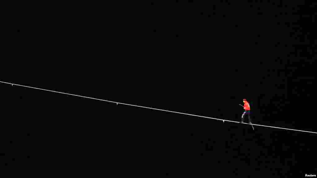 Nik Wallenda đi trên dây căng từ tòa nhà phía tây của Marina Tower cao 180m sang đỉnh của tòa nhà Leo Burnett cao 204,5m ở Chicago, Illinois, ngày 2/11/2014.