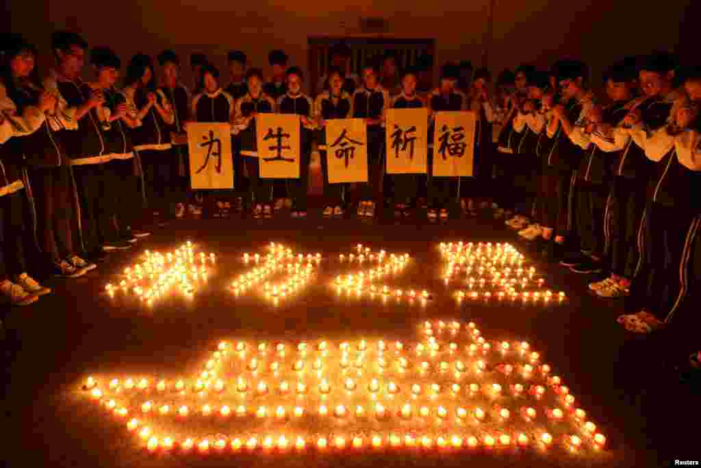 Numa escola de Zhuji, estudantes rezam pelos passageiros de um navio de cruzeiro afundado. Povíncia de Zhejang, China. June 3, 2015 &nbsp;