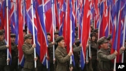 지난 10일 평양에서 열린 7차 노동당 대회 경축 군중집회에서 군인들이 북한 인공기를 들고 행진하고 있다.