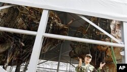 South Korean Rear Admiral Park Jung-soo talks in front of wreckage of the salvaged naval vessel Cheonan, 19 May 2010