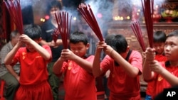 Indonesian ethnic Chinese children pray at a temple in the China Town in Jakarta, Indonesia, January 7, 2012. 
