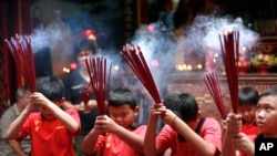 FILE - Indonesian ethnic Chinese children pray at a temple in the China Town in Jakarta, Indonesia.