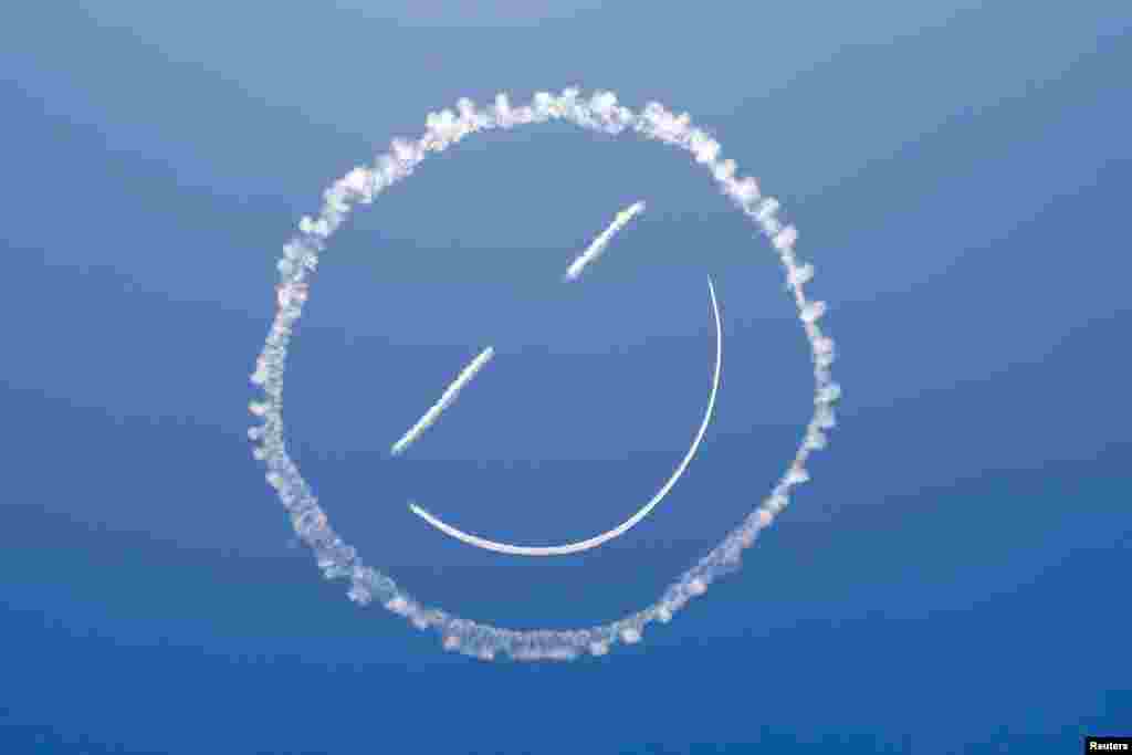 A sky writer draws a smiley face in the sky at the start of the Los Angeles County Air Show at General William J. Fox Airfield in Lancaster, California, Mar. 21, 2014. 