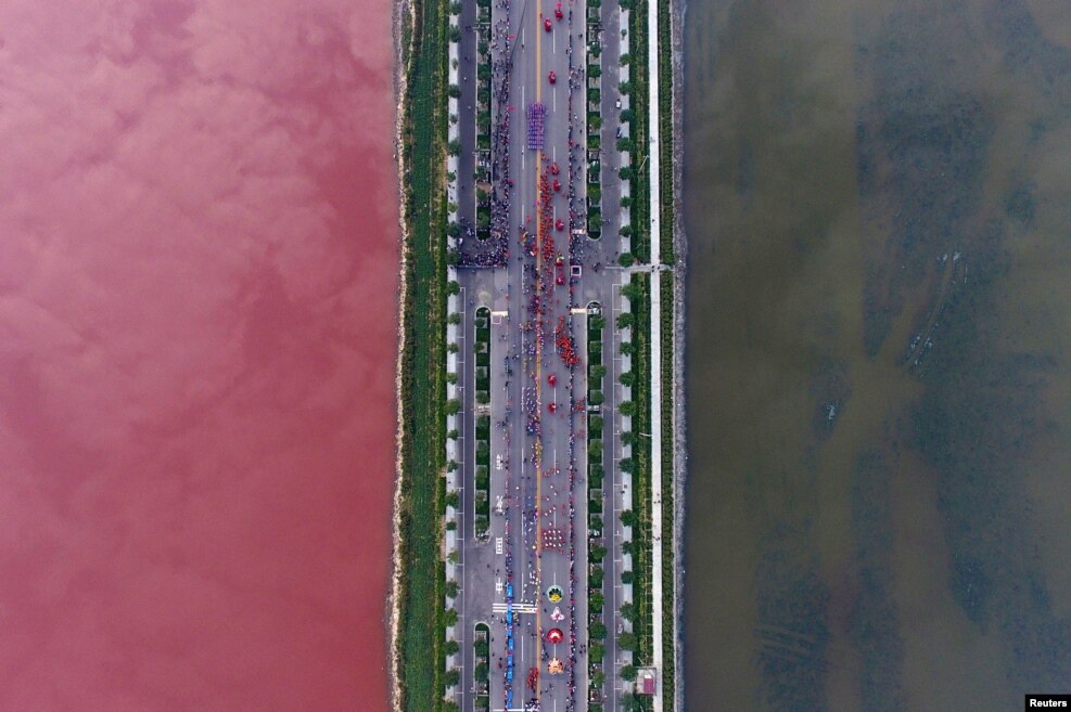 A salt lake which is separated by a road, shows parts of it in different colors due to algae, in Yuncheng, Shanxi Province, China, Sept. 25, 2016.