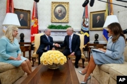 President Donald Trump and first lady Melania Trump meet with Israeli Prime Minister Benjamin Netanyahu and his wife Sara Netanyahu in the Oval Office of the White House, March 5, 2018, in Washington.
