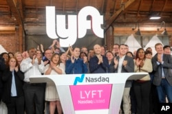 Lyft co-founders John Zimmer, center left, and Logan Green, center right, attend Lyft's IPO event in Los Angeles, March 29, 2019.