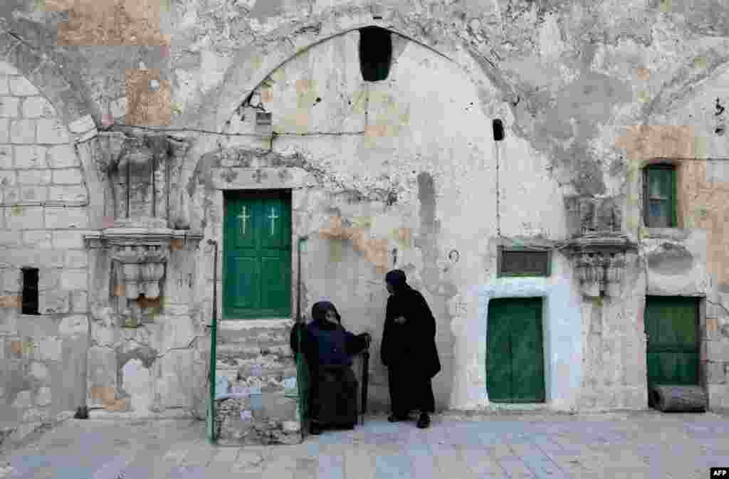 Caretakers of the Ethiopian Orthodox Monastery talk to each other at the Church of the Holy Sepulchre in Jerusalem.