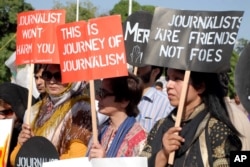 FILE - Pakistani journalists are seen rallying in support of their colleague Hamid Mir, who was shot and injured by gunmen in Karachi, April 23, 2014.