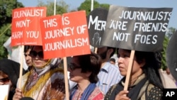 FILE - Pakistani journalists are seen rallying in support of their colleague Hamid Mir, who was shot and injured by gunmen, in Karachi, April 23, 2014. Many believe the attack was intended to send a message.