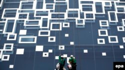 Workers decorate window on a high rise building of a renovation shopping mall in Bangkok, Thailand, 03 May 2016.