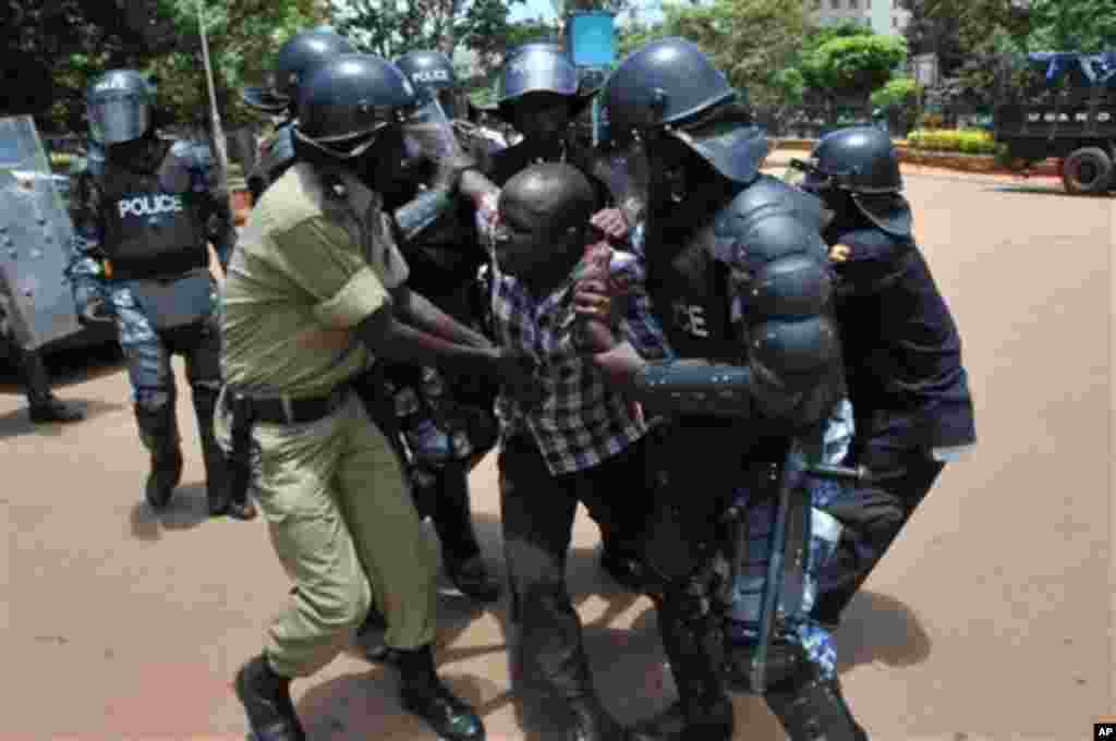 Uganda police detain a supporter of Uganda's top opposition leader Kizza Besigye outside the court in Kampala, Uganda, Wednesday, March 28, 2012. Besigye and his co-accused pleaded not guilty Wednesday and were freed on bail, from charges of convening an