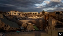 Buildings destroyed in the Bab al-Aziziya compound and an occupied intact building in Tripoli, Libya Nov. 26, 2013(AP Photo/Manu Brabo)
