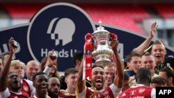 Striker Arsenal asal Gabon, Pierre-Emerick Aubameyang, memegang trofi merayakan kemenangan setelah pertandingan sepak bola final Piala FA antara Arsenal dan Chelsea di Stadion Wembley di London, pada 1 Agustus 2020. (Foto: AFP)