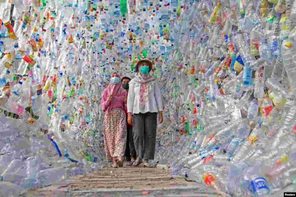 Warga berjalan melalui &quot;Terowongan 4444&quot; yang dibangun dari botol-botol plastik yang dikumpulkan dari beberapa sungai di sekitar kota dalam tiga tahun, di museum plastik yang dibangun oleh kelompok aktivis lingkungan Indonesia &quot;ECOTON&quot; di Gresik, Jawa Timur (Foto: Prasto Wardoyo/Reuters).