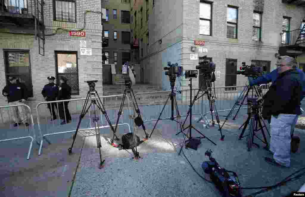 Media and police stand outside a Bronx, New York apartment building from where a 5-year-old boy who arrived from Guinea was taken to Bellevue Hospital in New York to be tested for the Ebola virus, Oct. 27, 2014. 