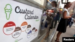 A woman stands near a menu of a Shake Shack restaurant in the Manhattan borough of New York, August 15, 2014. (REUTERS/Carlo Allegri )