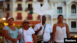 FILE - Activists take part during a demonstration to protest violence against women in Cartagena, Colombia, Oct. 27, 2016. 