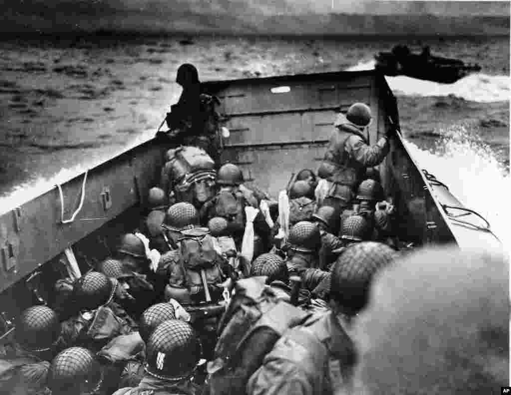 CORRECTS DATE OF PHOTO, REMOVES REFERENCE TO TODAY - FILE - In this June 6, 1944, file photo, Allied troops crouch behind the bulwarks of a landing craft as it nears Omaha Beach during a landing in Normandy, France. The D-Day invasion broke through Adolf