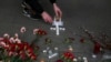 A man lights candles arranged in a form of a cross at a symbolic memorial outside Sennaya subway station in St. Petersburg, Russia, April 4, 2017. 