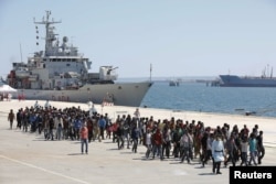 FILE - Migrants are disembarked from the Italian navy ship 'Vega' in the Sicilian harbour of Augusta, southern Italy, May 4, 2015.