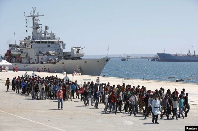 FILE - Migrants are disembarked from the Italian navy ship 'Vega' in the Sicilian harbour of Augusta, southern Italy, May 4, 2015.