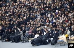 People wounded in the November 13 Paris attacks wait for the start of a ceremony in the courtyard of the Invalides in Paris, Nov. 27, 2015.