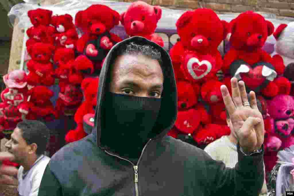 A protester flashes the four finger sign representing Rabaa on the six month anniversary of the violent crackdown against supporters of ousted President Mohamed Morsi, Feb. 14, 2014. (Hamada Elrasam/VOA) 