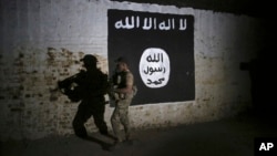 FILE - An Iraqi soldier inspects a train tunnel, adorned with an Islamic State group flag, that was used as training camp for IS fighters, in western Mosul, Iraq, March 1, 2017.