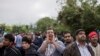 A man shouts while people wait to clear a police line as they entered into Croatia from Serbia, in Babska, Croatia, Sept. 25, 2015.